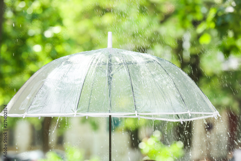 Transparent umbrella outdoors on rainy day