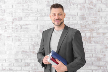 Wall Mural - Handsome male teacher against brick wall