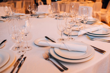 Round white table with elegant compositions from natural flowers. Banquet at the luxury wedding. Elegant design wedding table.