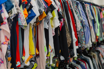 Beautiful colorful clothes in a store on hangers.