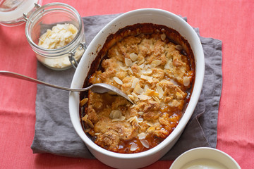 Wall Mural - Overhead image of plum cobbler with almond flakes and cream