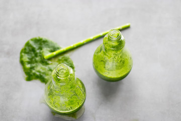 Two glasses of wheatgrass juice on gray background.  Vitgrass.