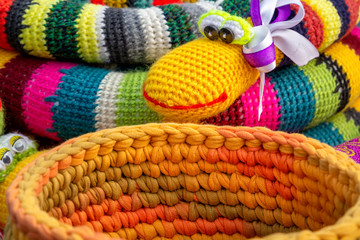 Wall Mural - Colorful crocheted handmade toys snake and basket for sale in a souvenir shop on the market. Close-up