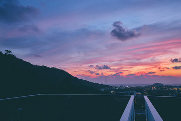 Wall Mural - Peaceful sunset in the city. Beautiful landscape with sea, purple sky and cityscape.