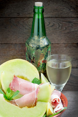 Wall Mural - Melon (cantaloupe) with prosciutto  and wine onrustic table