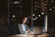© mavoimages - Young businesswoman working online in an office at night