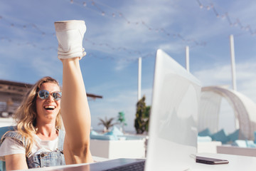 Laughing cheerful young girl student rejoices at her successful life and relaxing at sea resting during a vacation on a sunny warm summer day. Happy life and vacation concept