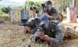 © JackF - Paintball players aiming and shooting with guns at opposing team outdoors