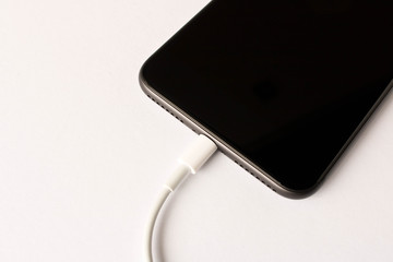 Smartphone on charge . On white background. Close up.