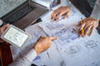 © Ngampol - Construction engineering discussing a blueprint while checking information