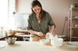 © Seventyfour - Waist up portrait of female ceramist working in pottery studio, copy space