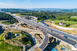 New highway under construction in Poland on national road no 7, E77, called Zakopianka.  Overpass crossroad with traffic circles and viaducts near Naprawa village. Aerial view in June 2019