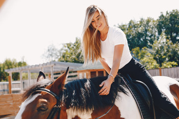 Cute girl with a horse. Lady in a white t-shirt. Woman in a summer park