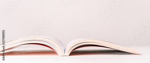 Cuadros en Lienzo Close view of an open book in a pink design on a pink pastel background with copy space