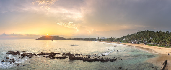 Wall Mural - tropical beach with rocks on sand coast of ocean