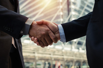 Wall Mural - Partnership. close up business man in modern suit hands shaking after finishing up a business meeting in the city, congratulation, success, meeting, partner, handshake, teamwork and connection concept