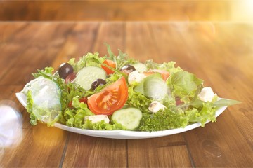 Canvas Print - Individual side serving of delicious fresh Greek salad with feta cheese, olives, tomatoes and salad greens