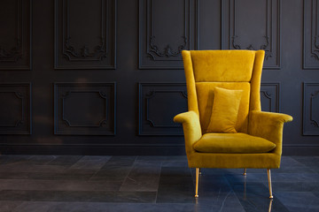 stylish bright yellow chair against a dark gray wall
