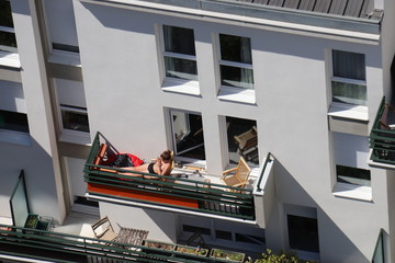 Sticker - Jeune femme bronzant sur un balcon à Paris