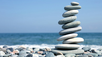 folded pyramid of smooth stones on the seashore.