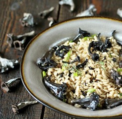 Wall Mural - black chanterelle risotto. Black Trumpet mushrooms recipe. Italian food. place for text. copy space.