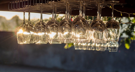 Group of crystal glasses for wine or champagne. Reflections of sun rays in the glass at sunset