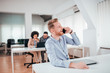 © bnenin - Millennial businessman talking on mobile phone in modern co working office.