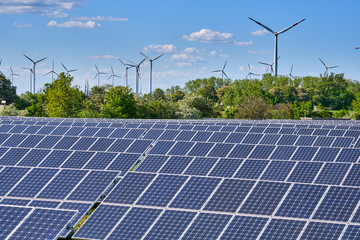 solar panels with wind turbines in the back seen in germany
