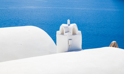 beautiful Oia town on Santorini island, Greece. Traditional white architecture and greek orthodox churches with blue domes over the Caldera, Aegean sea. Scenic travel background