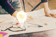© peshkova - View of Bulb lamp idea concept icon on a futuristic interface with writing man's hand background. Double exposure.
