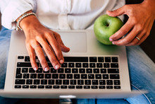 Modern Technology Business Activity Concept And Healthy Lifestyle For People - Above View Of Keyboard Laptop Computer And Woman's Hands Typing - Green Apple - Casual Clothes - Freelance Life