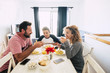 © simona - Cheerful people smiling happy family have lunch together at home - white backgorund and mother father and teenager son eating italian pasta enjoying the life together