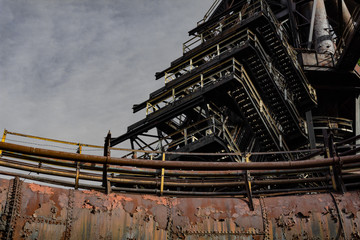 Wall Mural - Rusting metal pipe structure with graduating stairs, exterior steel mill complex, copy space, horizontal aspect