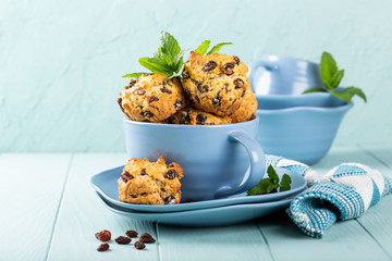 Wall Mural - Fresh homemade delicious raisin muffins in blue cup, sugar free. Healthy food concept with copy space.