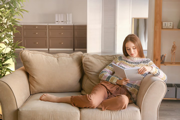 Wall Mural - Beautiful young woman reading book at home