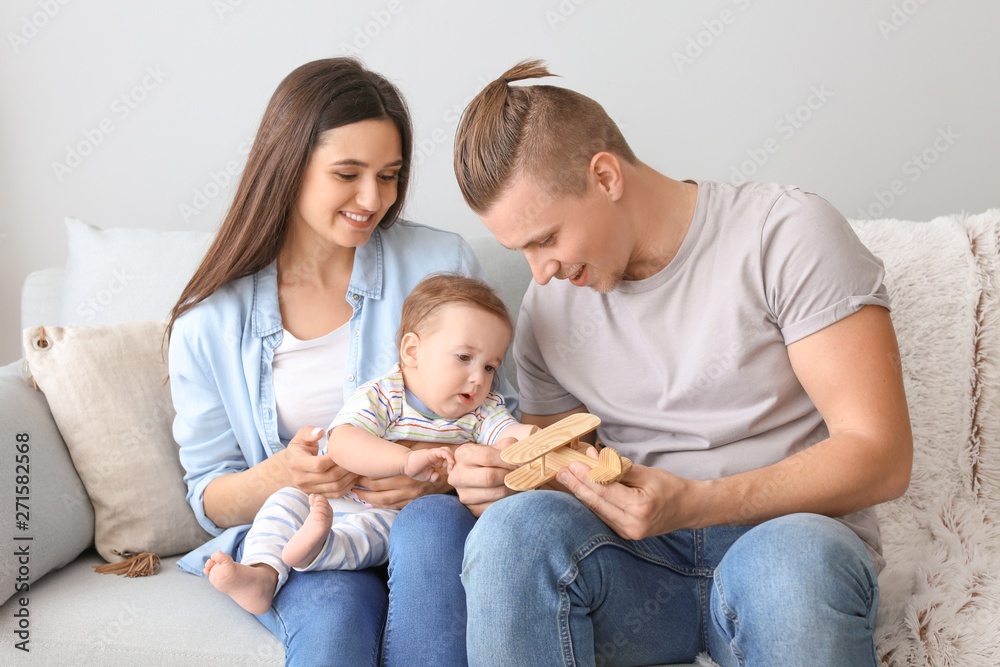 Happy parents with cute little baby at home