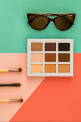 Wall Mural - Palette of shadows for a make-up and female trend accessories, on a geometrical multi-colored background, minimal, art, flatlay