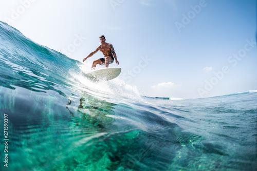 Dekoracja na wymiar mlody-czlowiek-surfuje-po-szklistej-fali-oceanu-w-sloneczny-dzien