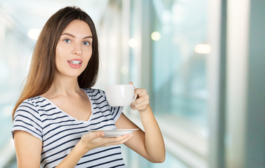 Canvas Print - Happy woman enjoying a warm cup of tea or coffee for breakfast