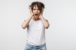 © Drobot Dean - Displeased shocked woman posing isolated over white wall background screaming.