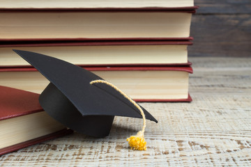 Wall Mural - education concept. Graduation hat with gold tassel on the books. Law concep- with copy space for your ad text.