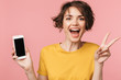 © Drobot Dean - Happy young beautiful woman posing isolated over pink wall background using mobile phone.