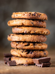 Chocolate chips cookies with crumbs on wooden background, homemade sweet and dessert concept