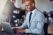 Smiling African American businessman working online in a modern