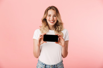 Sticker - Young blonde woman posing isolated over pink wall background using mobile phone showing display.