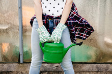 Young Woman Holding Green Watering Can