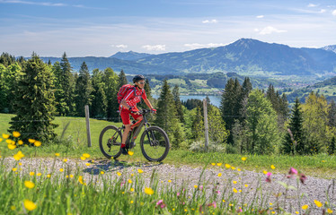 Wall Mural - senior woman mountainbiking on a e-mountainbike in early spring, in the Allgaeu Area, a part of the bavarian alps,Germany