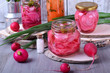 Chopped radish, carrot and red onion marinated in glass jars. Assortment of pickled vegetables
