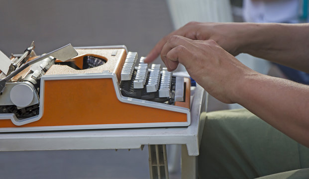 Young man working on old vintage manual typewriter