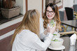 © Alvaro Hernandez/ADDICTIVE STOCK - Back view of two female friends smiling and clinking glasses of alcohol cocktails while spending time in bar of cozy restaurant